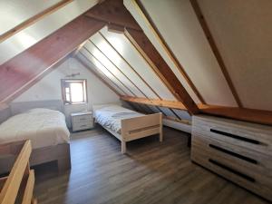 1 dormitorio en el ático con 2 camas y ventana en Griad in de Duinen en De Haan