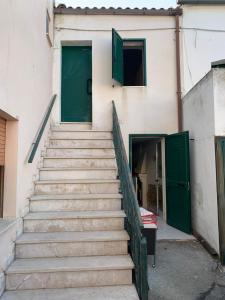 eine Treppe, die zu einem Gebäude mit grünen Türen führt in der Unterkunft Cannarsa in San Giacomo degli Schiavoni