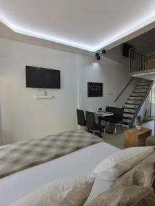 1 dormitorio con 1 cama y TV en la pared en Alfa Studio, en Kavala