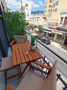una mesa y sillas de madera en un balcón en Alfa Studio, en Kavala