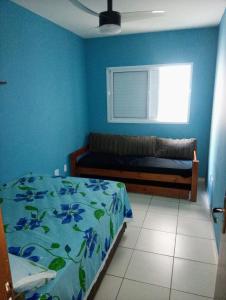 a blue bedroom with a bed and a window at Apartamento Vidal con Wi-Fi Praia Grande Avi in Praia Grande