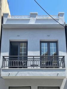 a white building with a balcony and two windows at Sogni D' Oro "Zen" in Zakynthos Town