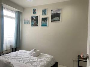a bedroom with a bed with pictures on the wall at 1 Bedroom Flat in Gramercy Residences Condo in Manila +72 photos