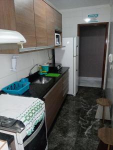 a small kitchen with a sink and a refrigerator at Apartamento Vidal con Wi-Fi Praia Grande Avi in Praia Grande
