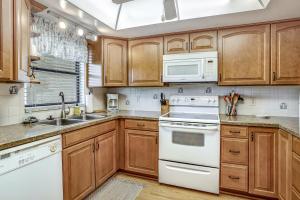 a kitchen with wooden cabinets and white appliances at Casa Bella Paradise in Fort Myers