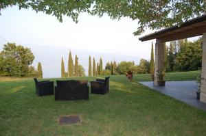 a group of chairs sitting in the grass at Agriturismo Casa del Castagneto in Gargnano