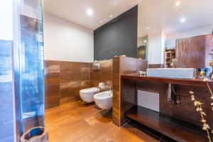 uma casa de banho com um WC, um lavatório e um espelho. em FLH Funchal Artistic Apartment with Balcony em Funchal