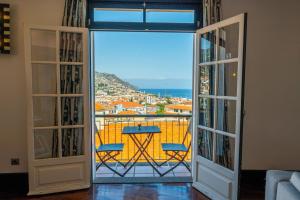 um quarto com uma varanda com vista para o oceano em FLH Funchal Artistic Apartment with Balcony em Funchal