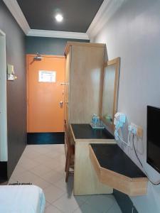 Cette chambre comprend une salle de bains pourvue d'un lavabo et d'un miroir. dans l'établissement V HOTEL, à Teluk Intan