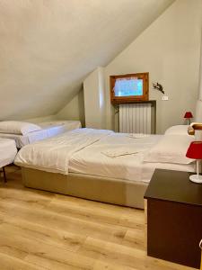 a bedroom with two beds and a tv on the wall at Villa sul Lago di Campotosto in Campotosto