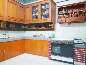 a kitchen with wooden cabinets and a stove top oven at Hostel Bogor in Bogor