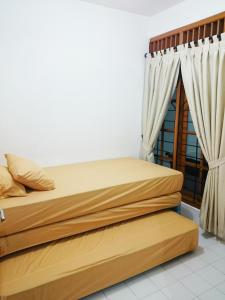 a bedroom with two beds and a window at Hostel Bogor in Bogor