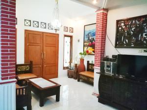 a living room with a door and a tv at Hostel Bogor in Bogor