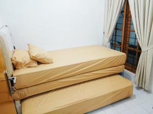 two beds sitting next to a window in a room at Hostel Bogor in Bogor