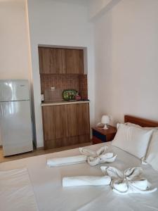 a bed with two white towels on it with a refrigerator at Sea View Studios Bali Harbour Beach in Balíon