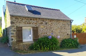 a small brick house with a window and plants at Maisonnette de bord de mer in Étables-sur-Mer