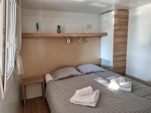 una camera da letto con un letto e due asciugamani di Premium Mobile Home ZEN SPOT 280 a Jezera