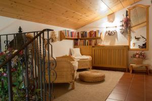 a living room with a couch and a chair and books at Landhaus Doris in Leutasch