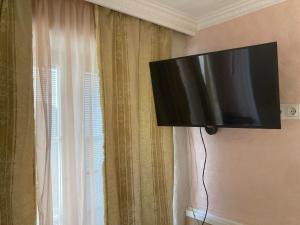 uma televisão de ecrã plano pendurada numa parede ao lado de uma janela em Renthouse Guest Apartment ALICE em Paide
