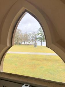 an arched window with a view of a park at 3 BR Luxury Apt at Highland Club - Fort Augustus in Fort Augustus