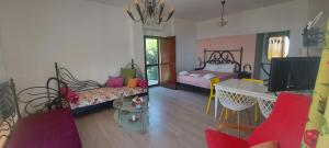 a room with a bedroom with two beds and a tv at Golden view apartments Myrina Limnos in Mirina