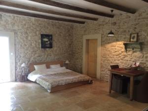 una camera con un letto in una stanza con pareti in pietra di Château de Peyrolles ad Apt