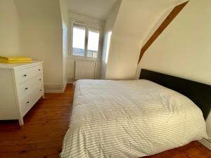 - une chambre avec un lit, une commode et une fenêtre dans l'établissement Appartement T4 place voltaire - 016, à Saint-Sever