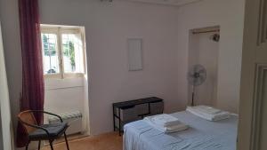 een slaapkamer met een bed, een stoel en een raam bij Villa Ottocento Molillo in Ostuni