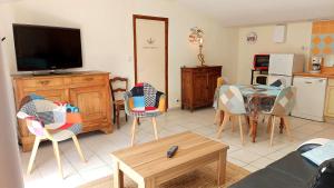 sala de estar con sillas, mesa y TV en MOULIN DE MAUZAC - Gîte Cap Océan, en Saint-Just