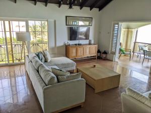 a living room with a couch and a coffee table at Breezy Ocean Front Condo Close to The Best Beaches in Christ Church