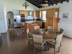 a kitchen with a dining room table and chairs at Breezy Ocean Front Condo Close to The Best Beaches in Christ Church