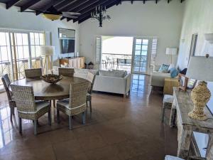a living room with a table and a couch at Breezy Ocean Front Condo Close to The Best Beaches in Christ Church
