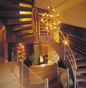 a woman standing at a counter under a spiral staircase at Hotel Zaragoza Plaza in Donostia-San Sebastián
