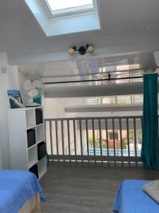 Schlafzimmer mit einem Dachfenster und einem Balkon in der Unterkunft Duplex vue océan in Biscarrosse