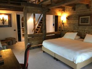 - une chambre avec un lit et un mur en bois dans l'établissement Relais du Chateau Blanc, à La Thuile