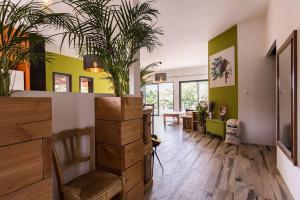 a living room with potted plants on the wall at Villa Parenthèse in Saint Alban Auriolles