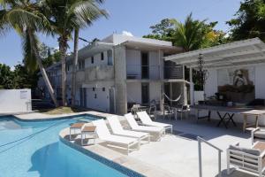een villa met een zwembad en ligstoelen bij Viento Beach Lodge in Dorado