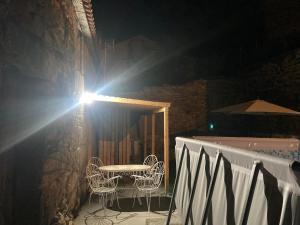 - une table et des chaises sur un balcon la nuit dans l'établissement Casa do Miguelo Costa da Morte, à La Corogne