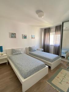 a bedroom with two beds and a window at Suites Setúbal - River View in Setúbal