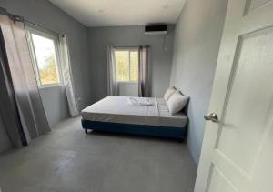 1 dormitorio con cama, ventana y puerta en Hilltop Condos, en Gros Islet