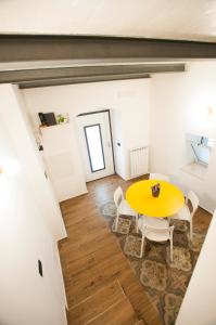 jadalnia z żółtym stołem i krzesłami w obiekcie Just Here apartments - Lascia Fare a Dio w mieście Bari
