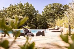 a wooden deck with chairs and a swimming pool at Villa Parenthèse in Saint Alban Auriolles +31 photos