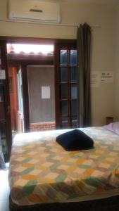 a bed with a pillow on it in a bedroom at Mi Casa Su Casa Lofts in Abraão