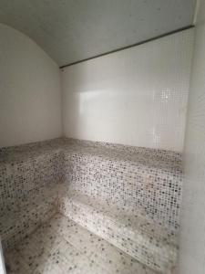 pusta łazienka z białymi płytkami na ścianie w obiekcie ARVA Spa París w mieście León