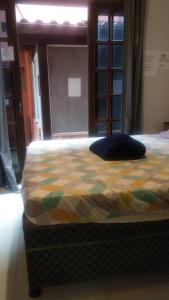 a bed with a colorful comforter in a room at Mi Casa Su Casa Lofts in Abraão