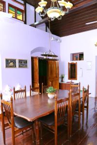 comedor con mesa de madera y sillas en Chiramel Residency, en Kochi