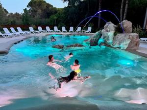 een groep mensen die zwemmen in een zwembad bij Bosco Canoro Bibione Resort in Bibione