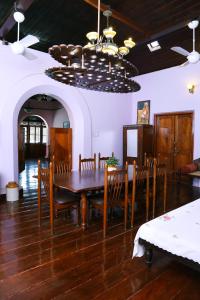 a dining room with a table and chairs and a chandelier at Chiramel Residency in Cochin