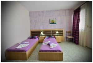 two beds in a small room with purple sheets at Anna Christina Apartments in Metamorfosi +56 photos