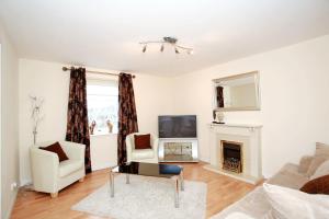 een woonkamer met een tv en een open haard bij Fonthill Apartments in Aberdeen
